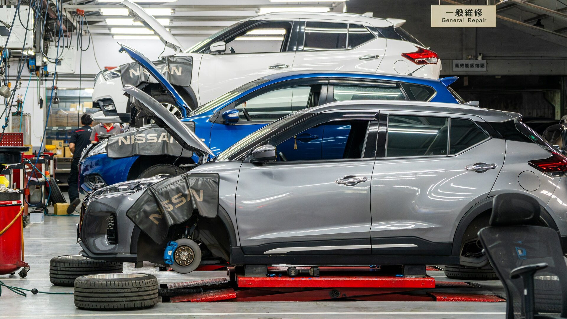 Tým autoservisu koordinuje zakázku v dílně